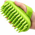 Green silicone scrubber held in a hand against a white background